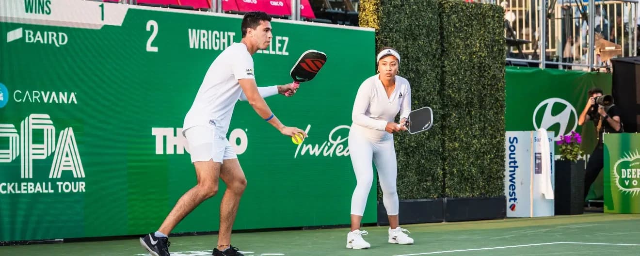 Pablo Tellez hits a serve next to Etta Wright at the PPA Masters.