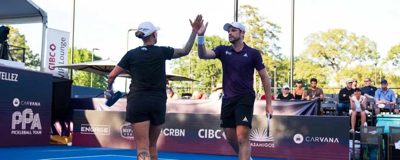 Tina Pisnik and Dekel Bar celebrate a pickleball point.