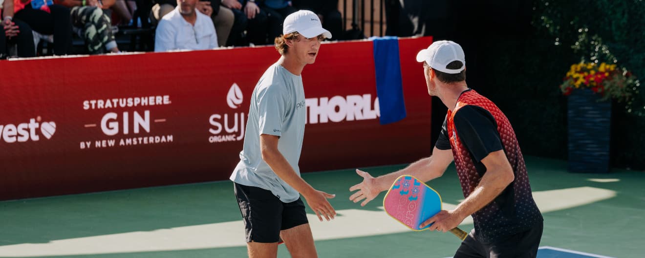 Gabriel Tardio and Andrei Daescu celebrate a pickleball point.