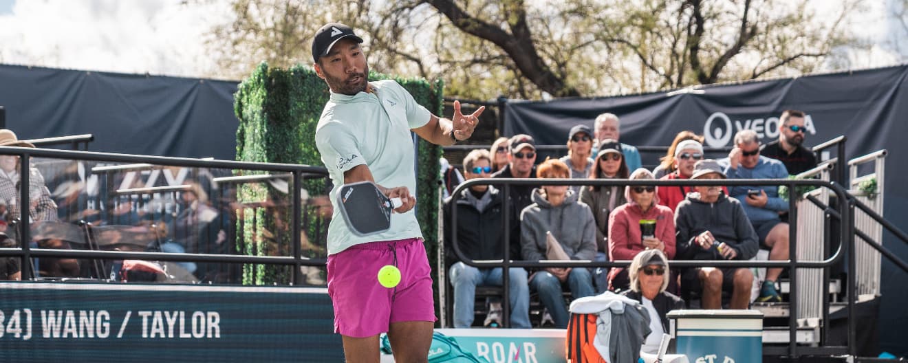 Chuck Taylor hits a pickleball serve.