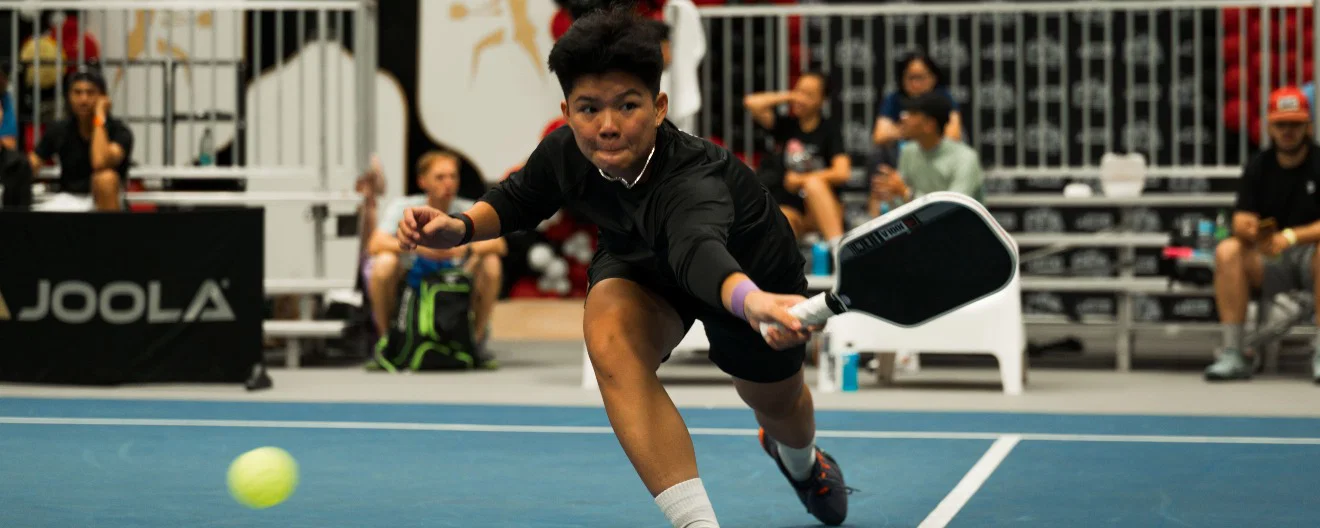 A player chasing a ball on the court.
