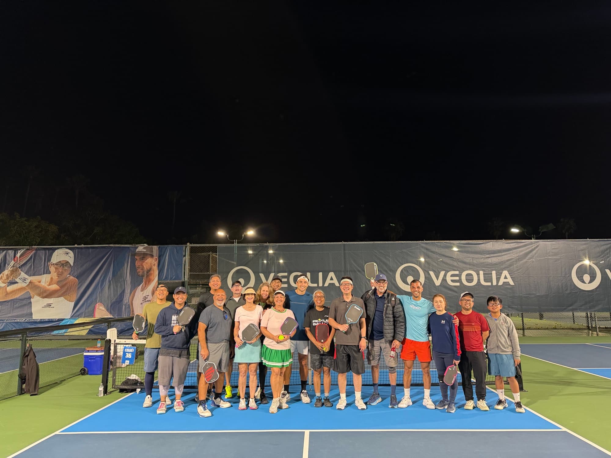 PPA Tour volunteers gathered on a championship court at night