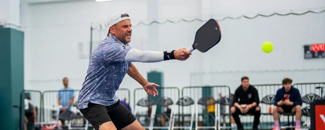 Steve Deakin hits a volley in pickleball.