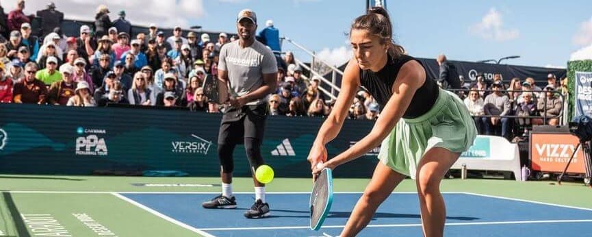 Angie Walker (wearing a green skirt) and Donald Young playing pickleball at Desert Ridge Open