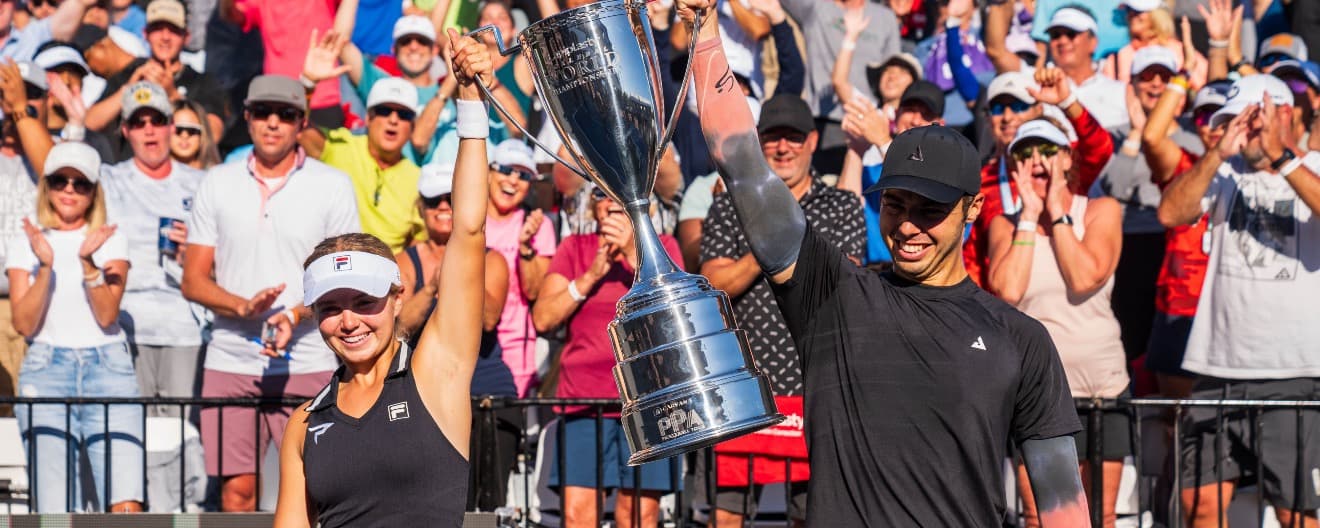 Anna Leigh Waters and Ben Johns holding up a trophy
