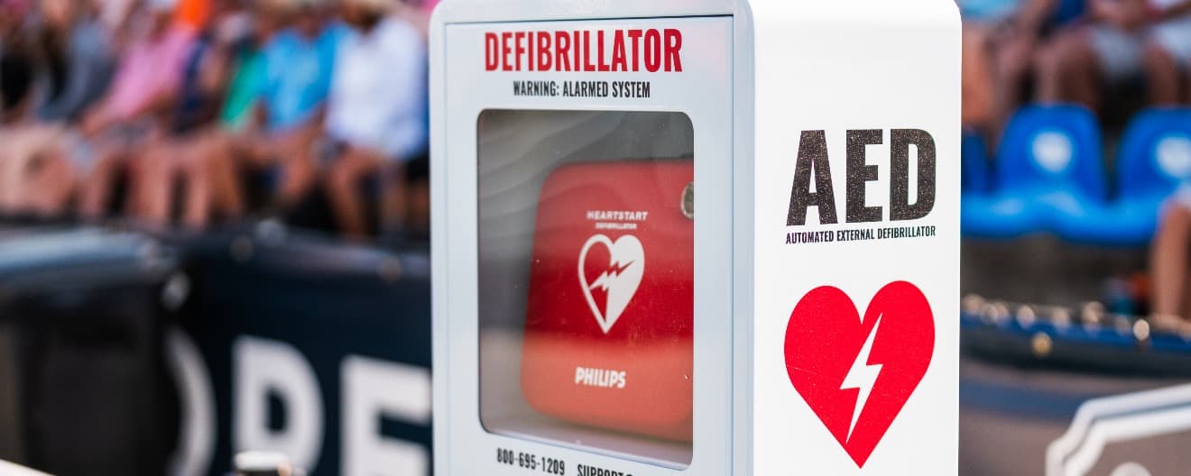 An AED alongside a pickleball court.