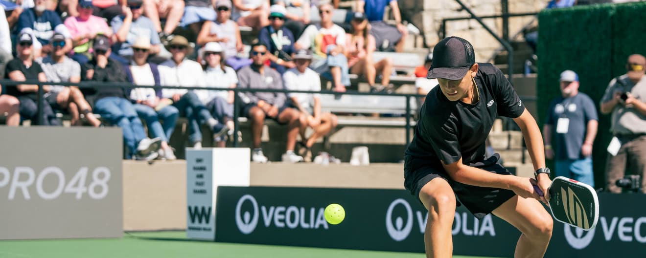 Tama Shimabukuro hitting a pickleball backhand.